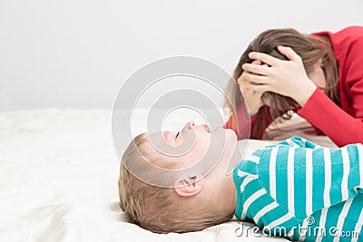 Mother is tired, child is crying Stock Photo