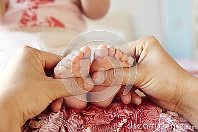 Mom massaging newborn's feet Stock Photo