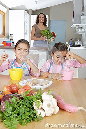Mother and Twins Beating Eggs in Kitchen Stock Photo