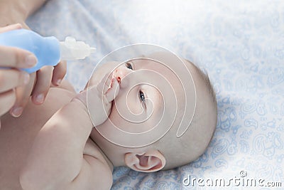Mother using baby nasal aspirator Stock Photo