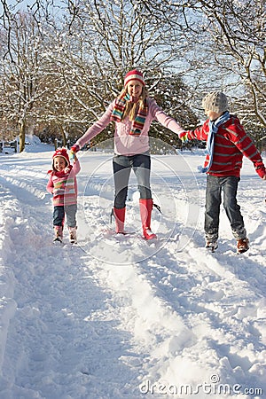Mother Walking With Children Through Snowy Landsca Stock Photo