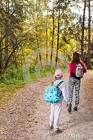 Mother walking with her child in warm sunny autumn day Stock Photo