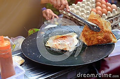 mother's hand is cooking egg martabak, traditional food from indonesia Stock Photo