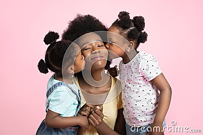 Motherhood and family concept. Lovely cute two little African girls kids in summer outfits, having fun and kissing their Stock Photo