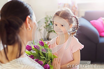 Mothers day, little girl giving flowers to her mum Stock Photo