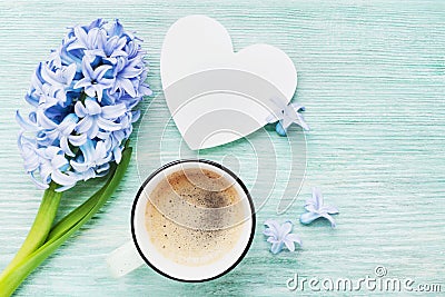 Mothers Day spring greeting background with hyacinth flowers, cup of coffee and white wooden heart top view. Morning breakfast. Stock Photo