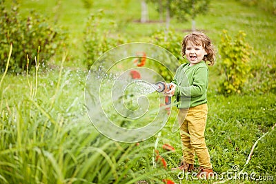 Mothers little helper watering the garden and having fun Stock Photo