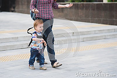 Mom insures her child during a walk Stock Photo