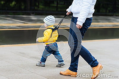 Mom insures her child during a walk Stock Photo