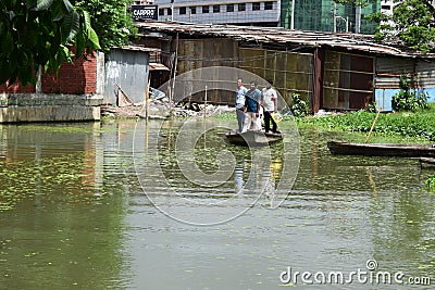 MOTIJHEEL,DHAKA/BANGLADESH-JULY 09 2020: Small Wooden Boat Carry Passenger In Small Lake Near Central Bank Of Bangladesh Editorial Stock Photo