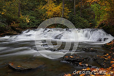 Motion-blurred water of Dingmans Creek surrounded by fall color Stock Photo
