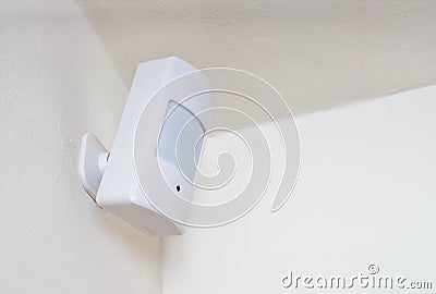 Motion sensor or detector for security system mounted on wall Stock Photo