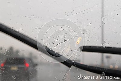 Motion of windscreen wipers on windshield with blurred traffic d Stock Photo