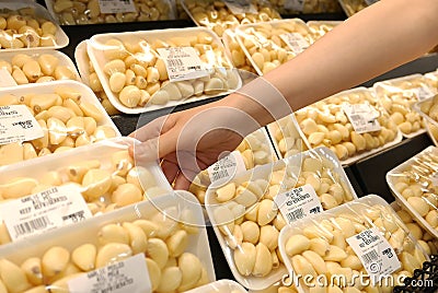 Motion of woman`s hand picking garlic inside superstore Editorial Stock Photo