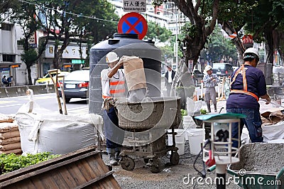 Motion of worker mixing cement for the preparation in construction site on road Editorial Stock Photo