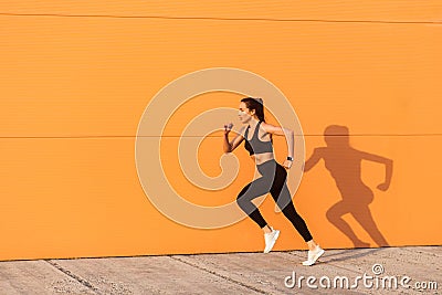 Motivated confident fit woman athlete in tight sportswear, black pants and top, starting to run, jogging outdoor Stock Photo