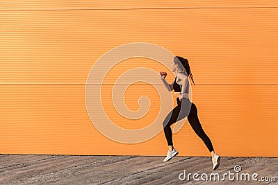 Motivated confident fit woman athlete in tight sportswear, black pants and top, starting to run, jogging outdoor Stock Photo