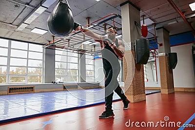 Motivated guy training with punching speed ball Stock Photo