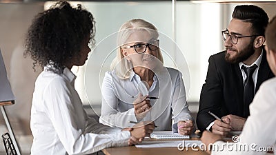 Motivated multiracial colleagues discuss ideas at meeting Stock Photo