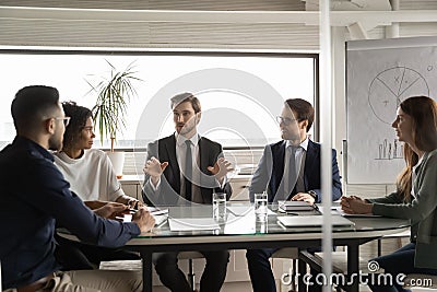 Motivated multiracial female and male colleagues discussing project. Stock Photo