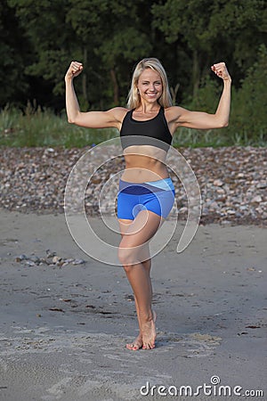 Motivated woman fitness exercising at beach Stock Photo