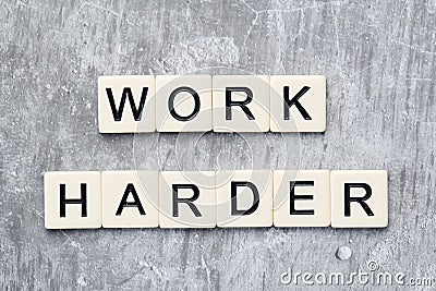 The motivating slogan Work Harder formed with tile letters Stock Photo