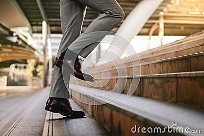 Motivation and challenging in Career Concept. Steps Forward into a Success. Low Section of Businessman Walking Up on Staircase. Stock Photo