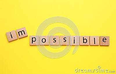 Motivation concept. Changing word from Impossible into Possible by removing squares with letters I and M on yellow background, top Stock Photo