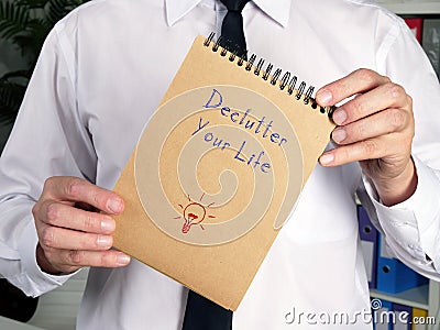 Motivational concept meaning Declutter Your Life S with sign on the piece of paper Stock Photo
