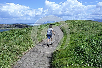 Motivational or inspirational concept Kid running up the hill Stock Photo