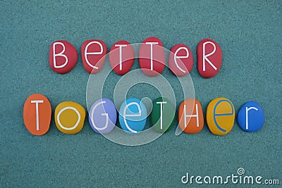 Better together, motivational slogan text composed with multi colored stone letters over green sand Stock Photo