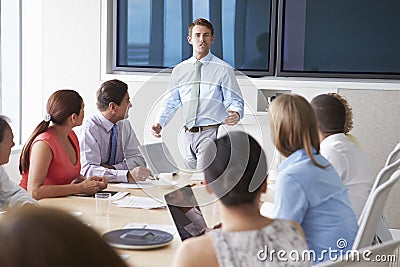 Motivational Speaker Talking To Businesspeople In Boardroom Stock Photo