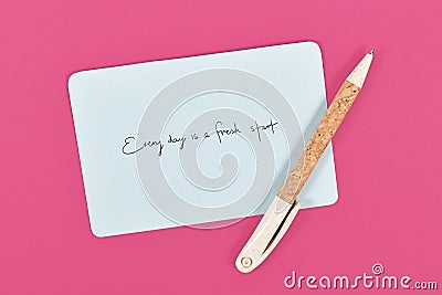 Motivational text `Every day is a fresh starts` on blue paper note Stock Photo