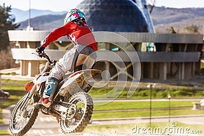 Moto cross biker at race- a sharp turn and the spray of dirt, rear view - close up Stock Photo