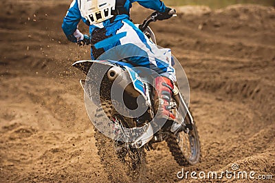 Moto cross - MX girl biker at race in Russia - a sharp turn and the spray of dirt, rear view - close up Stock Photo