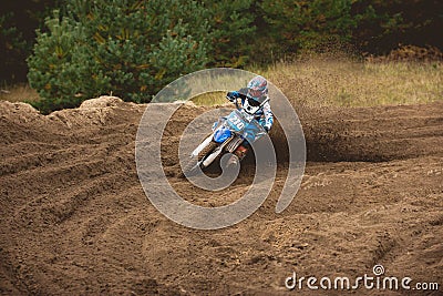 Moto cross - MX girl biker at race in Russia - a sharp turn and the spray of dirt Stock Photo