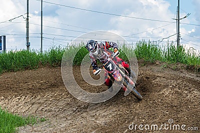 Motocross. Motorcyclist in a bend rushes along a dirt road, dirt flies from under the wheels. Active extreme rest Stock Photo