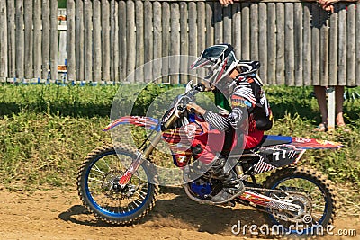 Motocross. Motorcyclist rushes along a dirt road, dust flies from under the wheels. Stock Photo