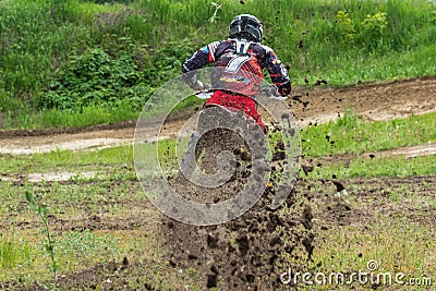 Motocross. Motorcyclist rushes along a dirt road, dirt flies from under the wheels. Stock Photo