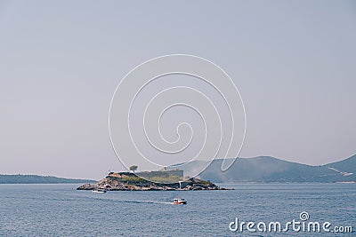 Motor boat sails along the Kotor Bay from the island of Mamula. Montenegro Stock Photo