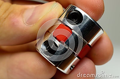 Motor coupling to reduce vibration and smooth start and running of mechanism is in the hand of a child. Stock Photo