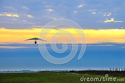 Motor hang glider in the cloudy sunset Stock Photo