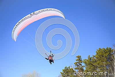 Motor paraplane flying over the forest Editorial Stock Photo