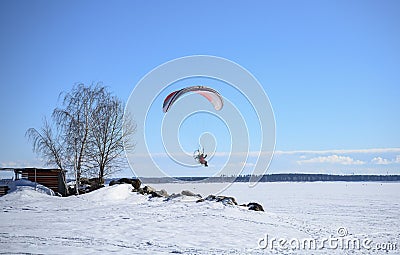 A motor paraplane flying over a frozen lake Editorial Stock Photo