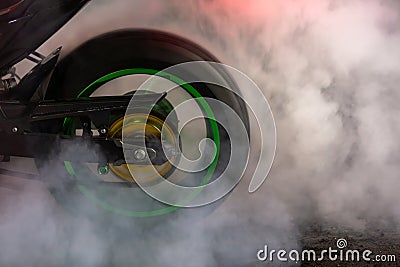 Motorbike burning tire rubber on road, Motorbike wheel drifting and white smoking on track, Motorcycle wheel on racing track with Stock Photo