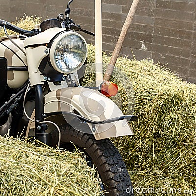 Motorbike stands amidst haystacks. Close-up. Square Stock Photo