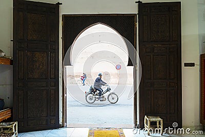 Motorbiker on the street of Marrakech captured through arabic gate Editorial Stock Photo