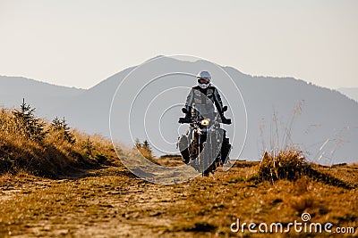 Motorbiker travelling in autumn mountains Stock Photo