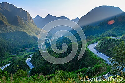 Motorbikers on winding roads through valleys and karst mountain scenery in the North Vietnamese region of Ha Giang / Van Stock Photo