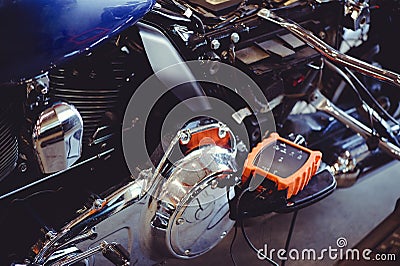 Motorcycle adjustment device. repair and programming of a motorcycle. The device is connected to workshop tools, a modern garage, Stock Photo